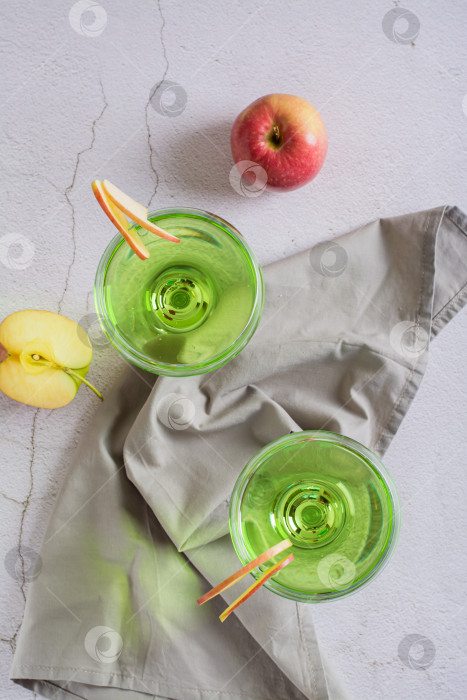 Скачать Освежающий яблочный мартини с фруктами в бокалах на столешнице фотосток Ozero