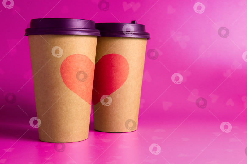 Скачать Пара бумажных стаканчиков с нарисованными на них сердечками на розовом фотосток Ozero