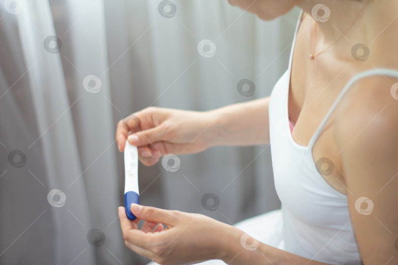 Положительный тест на беременность в руках у женщины