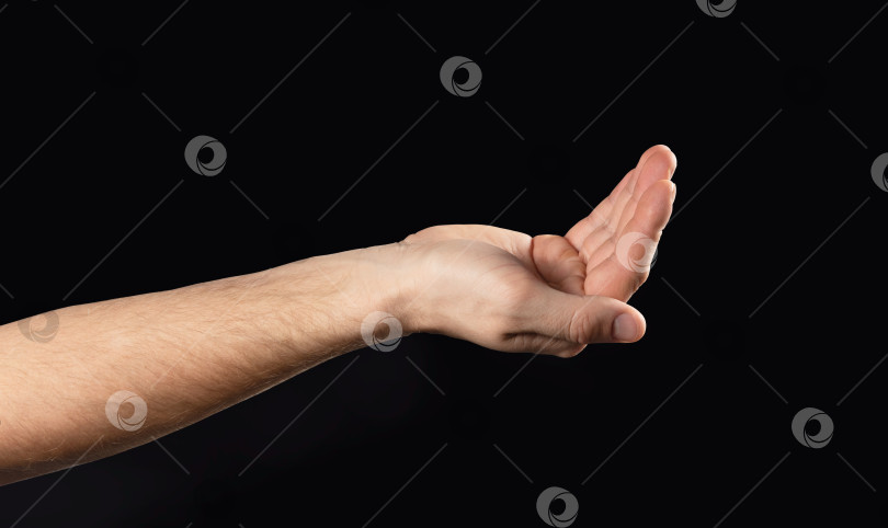 Скачать мужчина протягивает руку с чем-то. Выделенный на черном фоне фотосток Ozero
