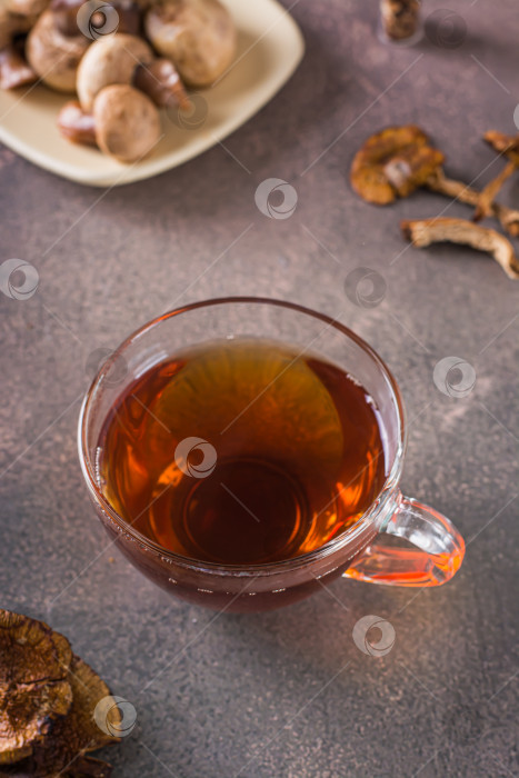 Скачать Домашний горячий чай из сушеных грибов в чашке на столе vert фотосток Ozero