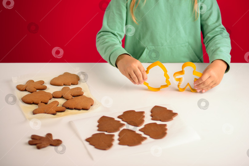Скачать Ребенок держит формочки для печенья в форме человечка и рождественской елки фотосток Ozero