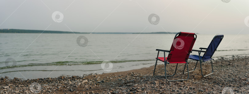 Скачать красные и синие стулья на пустынном пляже. концепция конца фотосток Ozero