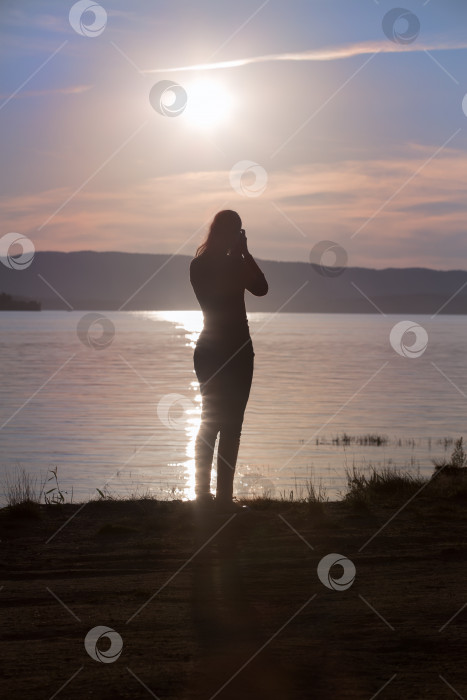 Скачать Девушка с фотоаппаратом фотографирует закат фотосток Ozero