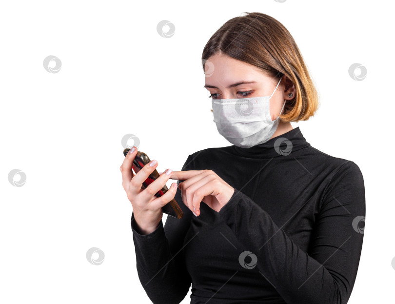 Скачать Молодая женщина в медицинской защитной маске со смартфоном фотосток Ozero