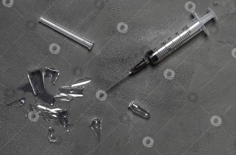 Скачать Одноразовый шприц и осколки разбитой медицинской ампулы. фотосток Ozero