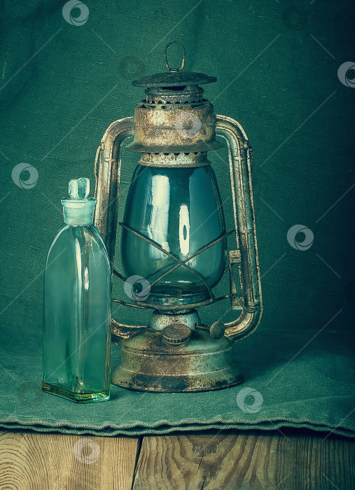 Скачать Ржавая керосиновая лампа и бутылка с керосином фотосток Ozero