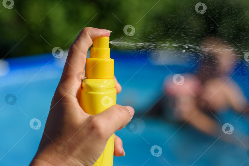 Скачать Нанесите на руки солнцезащитный крем для защиты кожи в бассейне. фотосток Ozero