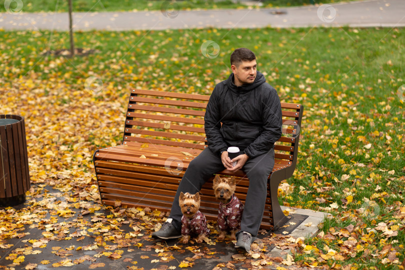 Скачать Мужчина сидит на скамейке в парке с чашкой кофе, два фотосток Ozero