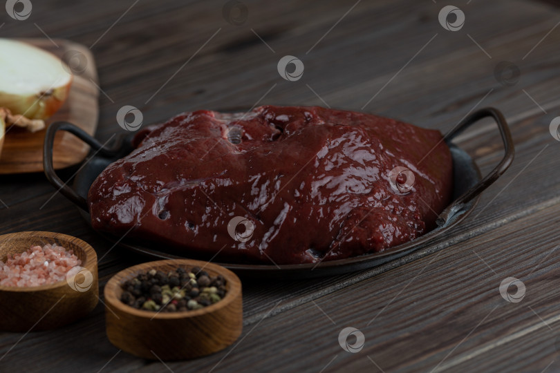 Скачать Сырая говяжья печень на металлической тарелке на деревянном фоне фотосток Ozero