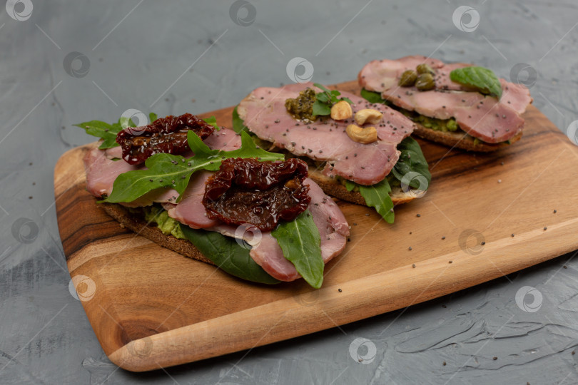 Скачать Ассорти из трех брускетт с мясом индейки, авокадо, помидорами фотосток Ozero