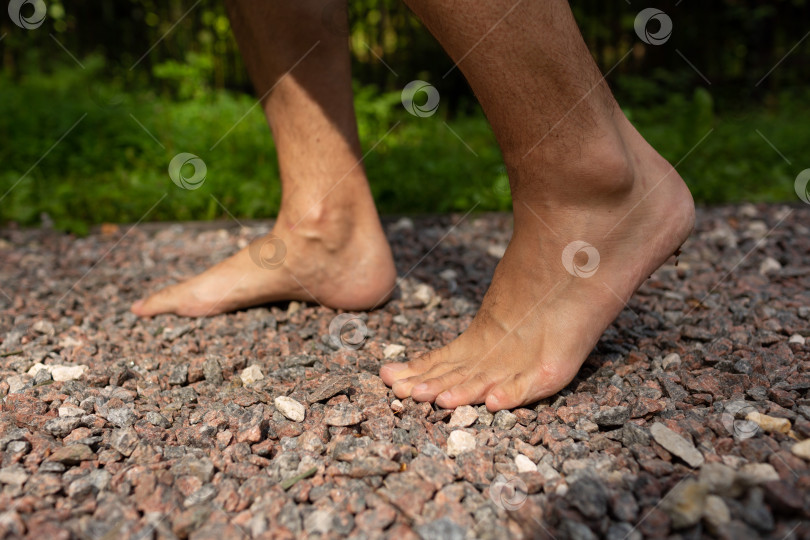 Скачать Мужчина ходит босиком по мелким камням фотосток Ozero
