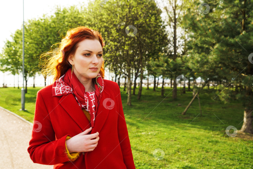 Скачать Красивая женщина в красном пальто на фоне парка фотосток Ozero