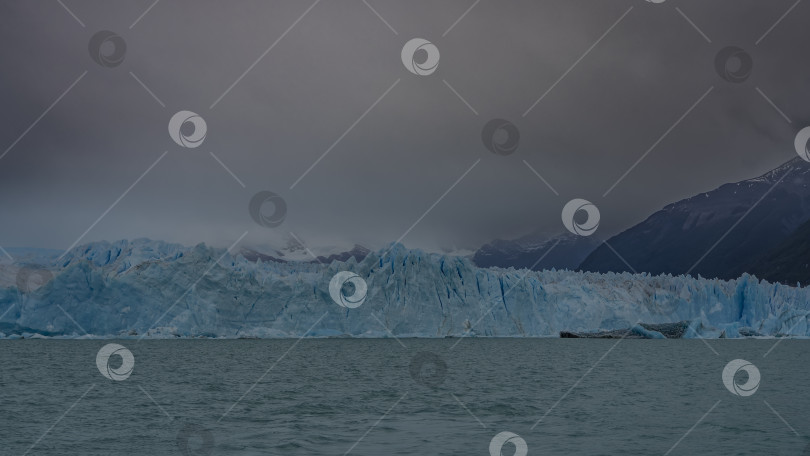 Скачать Знаменитый ледник Перито-Морено. Голубой потрескавшийся лед вздымается стеной фотосток Ozero