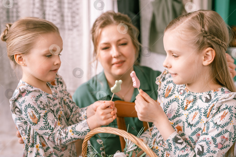 Скачать время пасхальных каникул в весенний сезон. счастливая семья откровенные маленькие дети сестры девочки вместе мама мама весело проводят время дома, контактируя, общаясь и играя. религиозная традиция фотосток Ozero