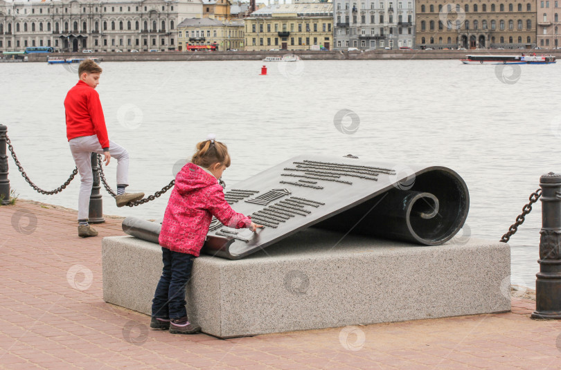 Скачать Девушка у памятного знака ЮНЕСКО на Заячьем острове. фотосток Ozero