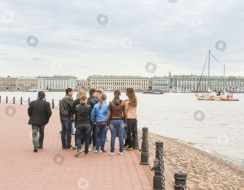 Скачать Группа молодых людей у ограждения набережной. фотосток Ozero