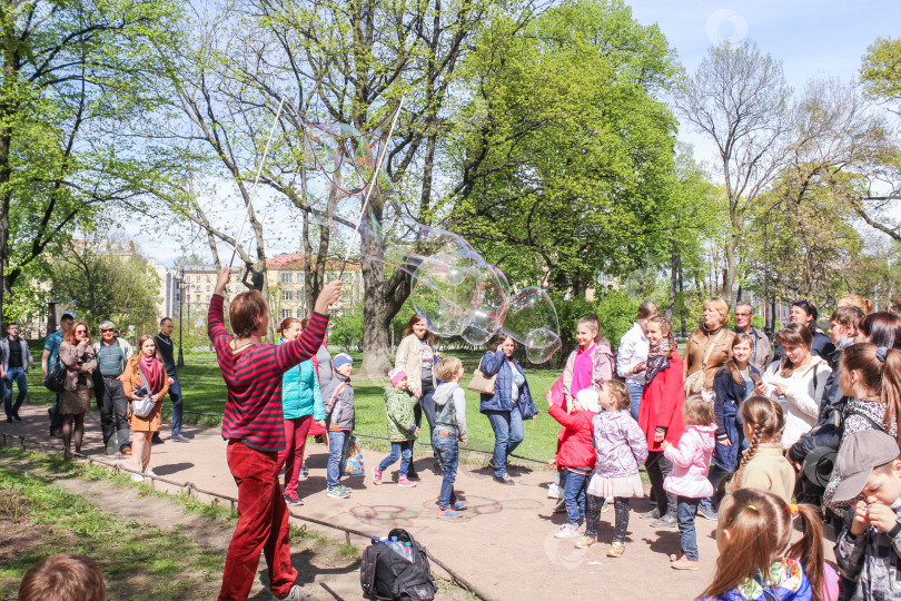 Скачать Люди в парке на шоу мыльных пузырей. фотосток Ozero