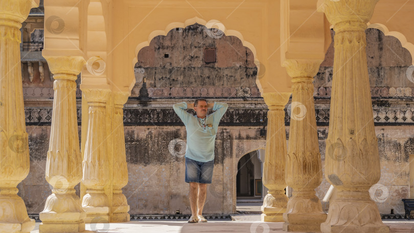 Скачать Павильон во внутреннем дворе форта Амбер, Джайпур. Мужчина стоит под аркой фотосток Ozero