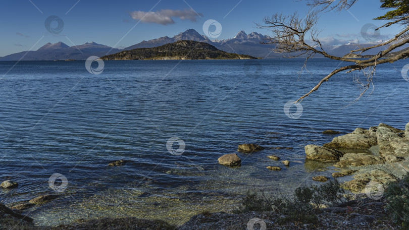 Скачать Красивое голубое озеро с прозрачной водой. У берега разбросаны валуны. фотосток Ozero