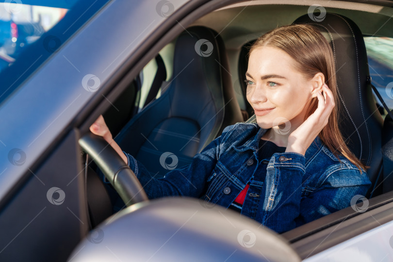 Скачать Красивая молодая леди довольна машиной. Симпатичная девушка, которая водит машину и улыбается. Портрет фотосток Ozero