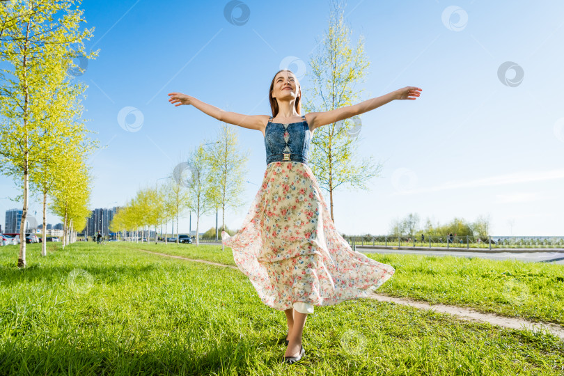 Скачать Красивая девушка на открытом воздухе наслаждается природой. Красивая модель в длинном платье развлекается фотосток Ozero