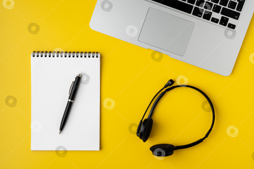 Скачать Современное рабочее пространство на желтом фоне. Записная книжка с ручкой, ноутбуком и цифровой гарнитурой фотосток Ozero