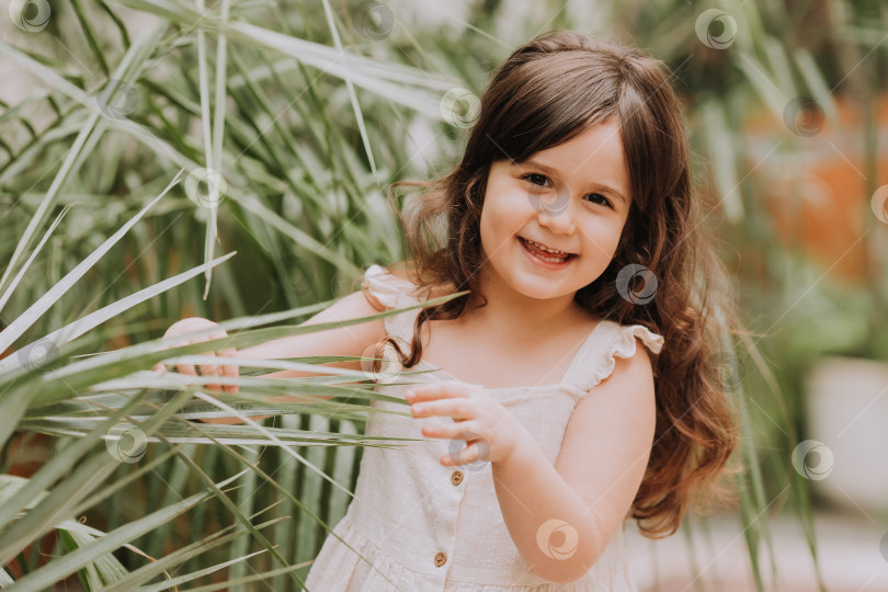Скачать маленькая девочка гуляет по ботаническому саду. счастливый ребенок и пальмы фотосток Ozero