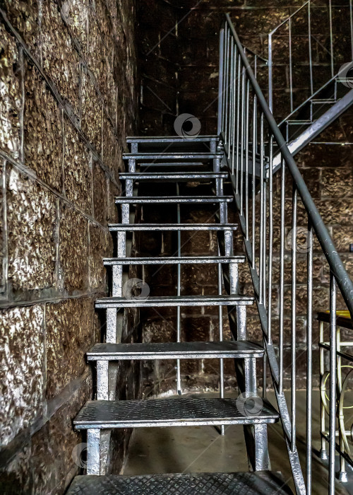 Скачать Металлическая лестница расположена рядом с кирпичной стеной. фотосток Ozero