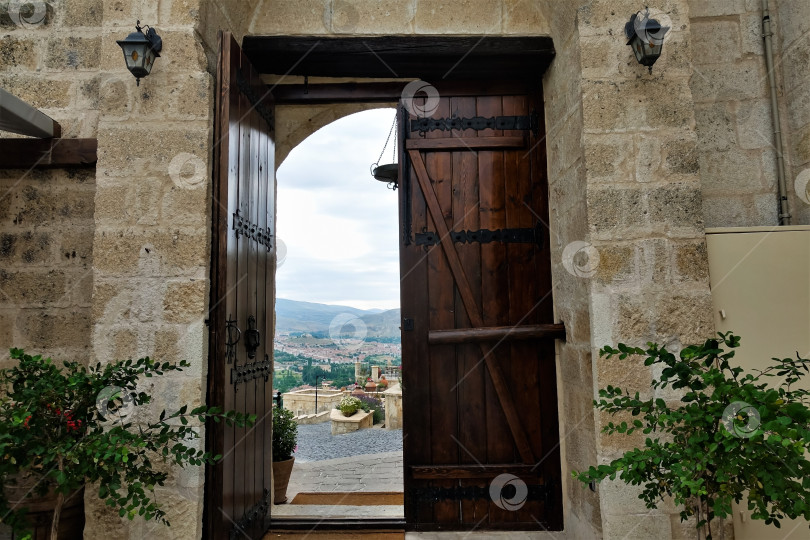 Скачать Дверной проем в каменной стене. Одна половина деревянной двери открыта. фотосток Ozero