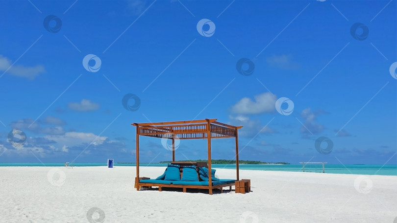 Скачать Мальдивский пляж. На белом песке есть навес с мягкими сиденьями. фотосток Ozero