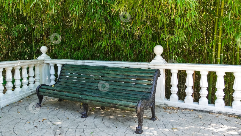 Скачать В тенистом уголке парка есть зеленая деревянная скамейка фотосток Ozero