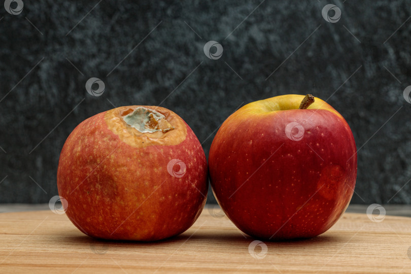 Скачать Гнилое яблоко с плесенью и свежее яблоко на темном фоне фотосток Ozero