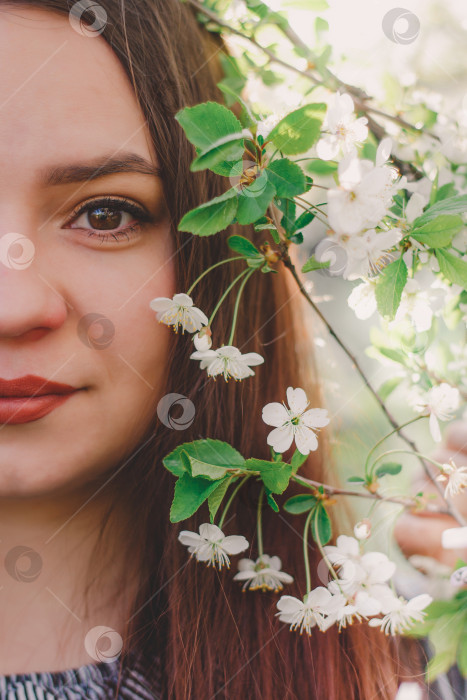 Скачать Половина прекрасного женского лица во время весеннего цветения. Красивая молодая девушка с карими глазами и белыми весенними цветами. Цветущая вишня. фотосток Ozero