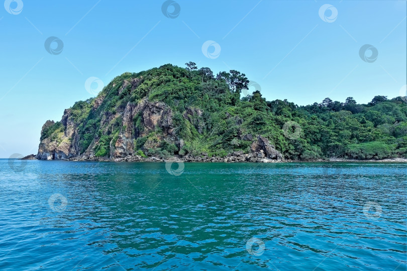 Скачать Остров с зеленой тропической растительностью возвышается над аквамариновой водой фотосток Ozero