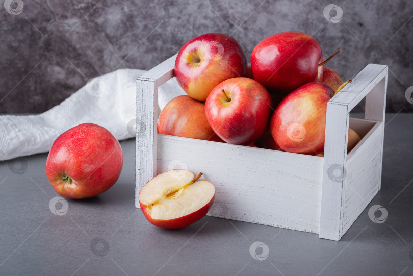 Скачать Свежие красные яблоки в деревянной коробке на сером фоне. Органический f фотосток Ozero