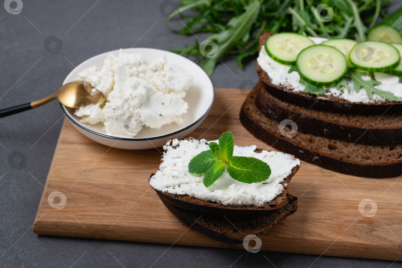 Скачать Ломтики ржаного хлеба с творогом и огурцами на сером хлебе фотосток Ozero