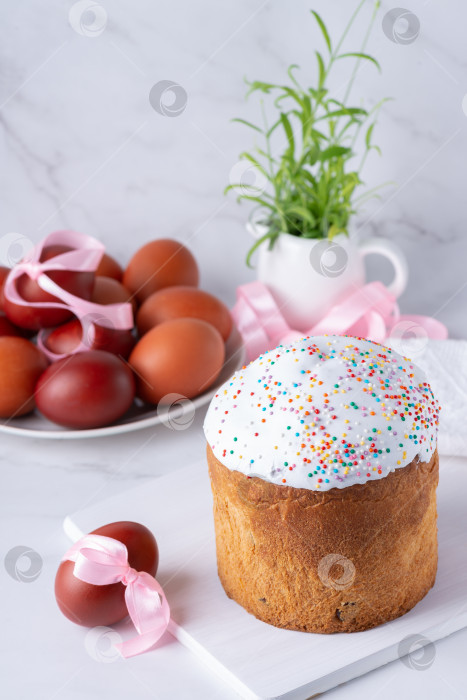 Скачать Традиционный пасхальный кулич или сладкий хлеб с яйцами на белом столе. фотосток Ozero