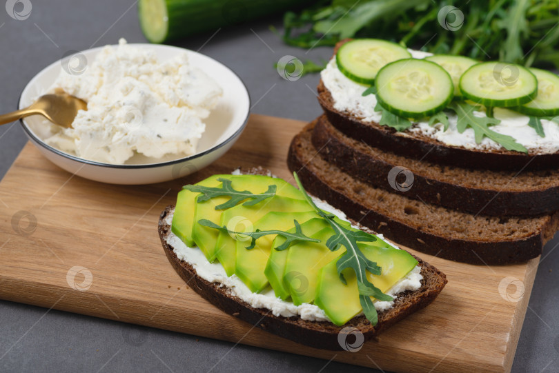 Скачать Полезный бутерброд с белым творогом, авокадо, огурцом и фотосток Ozero