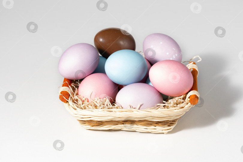 Скачать Корзина с пасхальными яйцами на белом фоне фотосток Ozero
