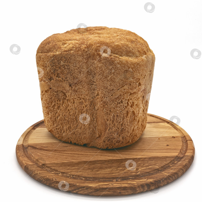 Скачать На круглой деревянной доске лежит высокая свежеиспеченная буханка хлеба. фотосток Ozero