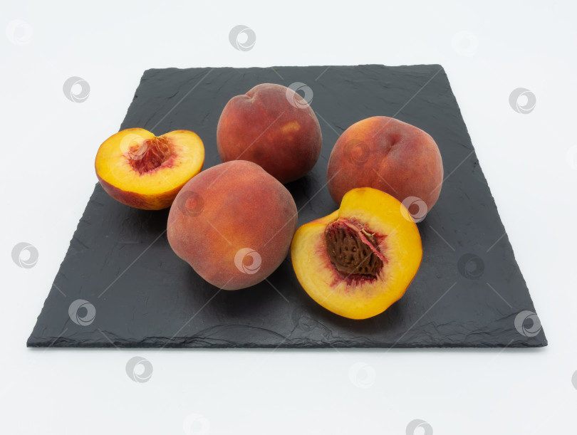 Скачать Спелые персики на черной квадратной тарелке. фотосток Ozero