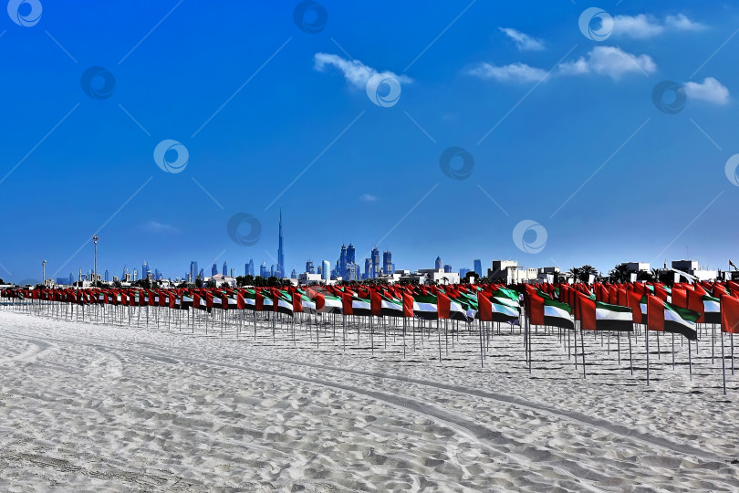 Скачать На чистом белом песке пляжа рядами разложены флаги красного, черного, белого и зеленого цветов. фотосток Ozero