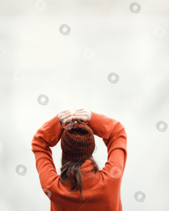 Скачать Девушка в оранжевом вязаном свитере и оранжевой вязаной шапочке фотосток Ozero