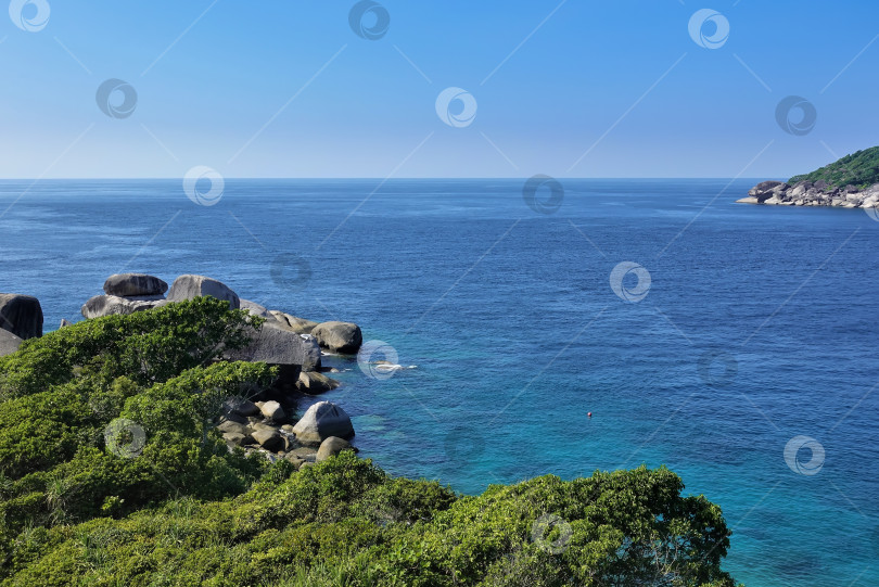 Скачать Большие валуны лежат на берегу зеленого тропического острова фотосток Ozero