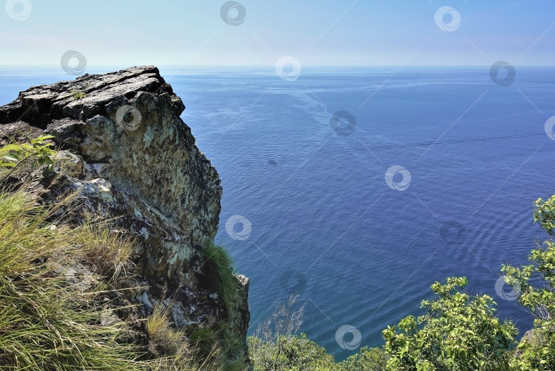 Скачать Скала с плоской вершиной возвышается над спокойным бирюзовым морем. фотосток Ozero