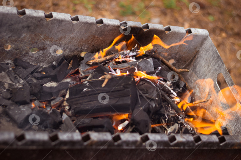 Скачать Пламя черных углей в металлическом гриле. фотосток Ozero