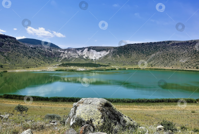 Скачать Круглое вулканическое озеро Нар окружено горными склонами. фотосток Ozero