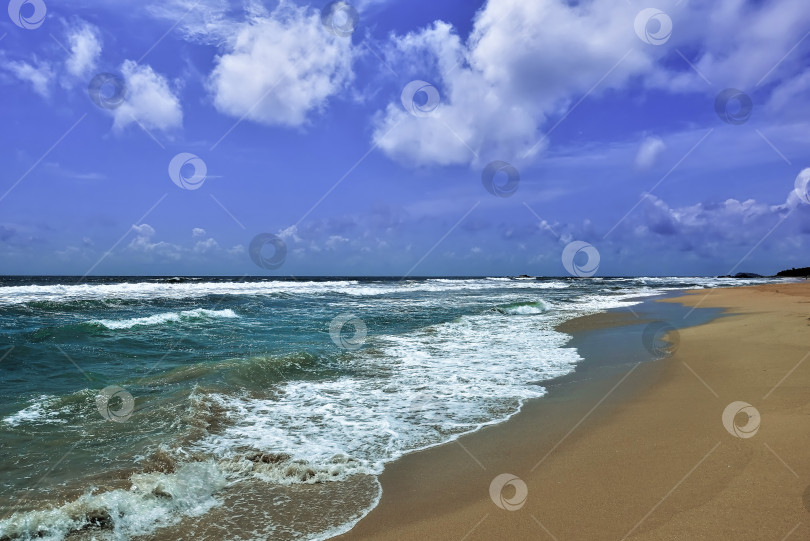 Скачать Занимайтесь серфингом в Индийском океане. Бирюзовые волны с нежной пеной накатываются на песчаный пляж. фотосток Ozero