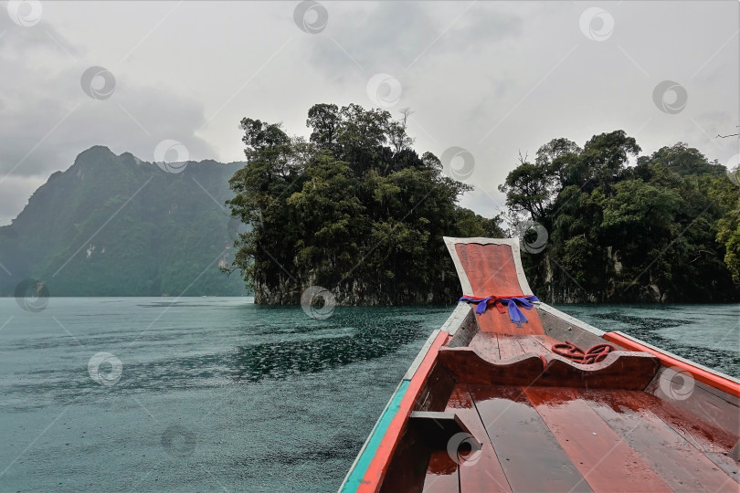 Скачать Туманный день на озере Чео Лан. Яркая длиннохвостая лодка плывет по воде. фотосток Ozero